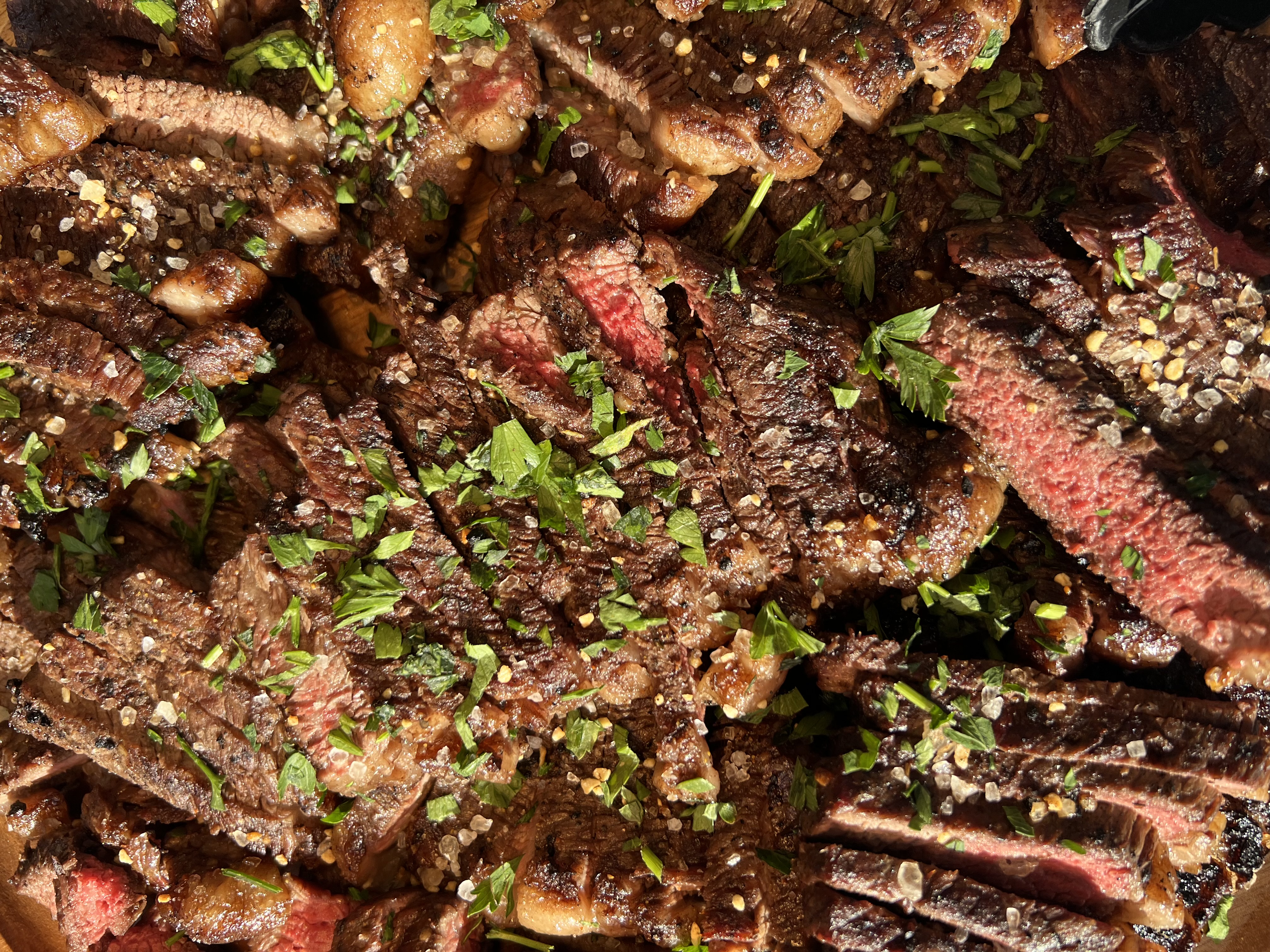 Sliced Prime picanha with fresh herbs and sea salt, ready for wedding guests